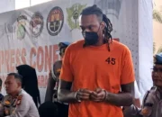 Pemain asing Tangerang Hawks Basketball, Jarred Dwayne Shaw (JDW) digiring petugas kepolisian Bandara Soetta usai ditampilkan ke hadapan publik dalam kasus narkoba, Tangerang Banten, Rabu (14/5/2025). (Anatara/Azmi Samsul Maarif)