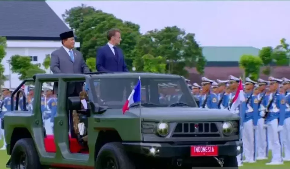 Presiden Prabowo Subianto (kiri) dan Presiden Prancis Emmanuel Macron menaiki kendaraan taktis Maung mengecek pasukan di Akademi Militer (Akmil) Magelang, Jawa Tengah, Kamis 29 Mei 2025. (© Antara)