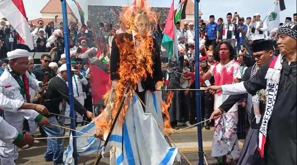Warga bakar bendera Israel dan boneka Perdana Menteri Benjamin Netanyahu dalam aksi bela Palestina di Tangerang, Minggu (20/4/2025) (Beritasatu/Wahroni)