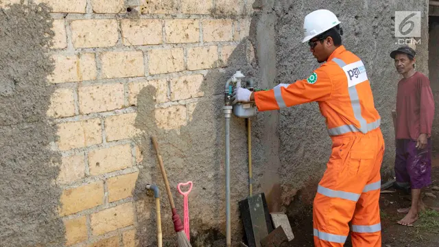 Petugas PT Perusahaan Gas Negara (PGN) memeriksa meteran jaringan gas bumi di perumahan warga di kawasan Cibinong, Bogor, Jawa Barat, Jumat (14/12). Pemerintah melalui PGN memberi tambahan 5.120 jargas pada tahun 2018. (Liputan6./Immanuel Antonius)