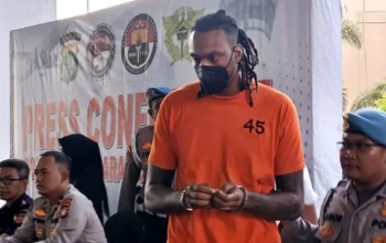 Pemain asing Tangerang Hawks Basketball, Jarred Dwayne Shaw (JDW) digiring petugas kepolisian Bandara Soetta usai ditampilkan ke hadapan publik dalam kasus narkoba, Tangerang Banten, Rabu (14/5/2025). (Anatara/Azmi Samsul Maarif)