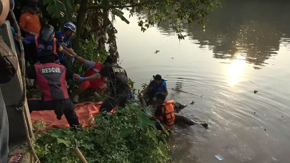 Petugas mengangkat mayat pria tanpa kelamin yang ditemukan di Sungai Rejoto, Mojokerto. (Beritasatu/Achmad Supriyadi)