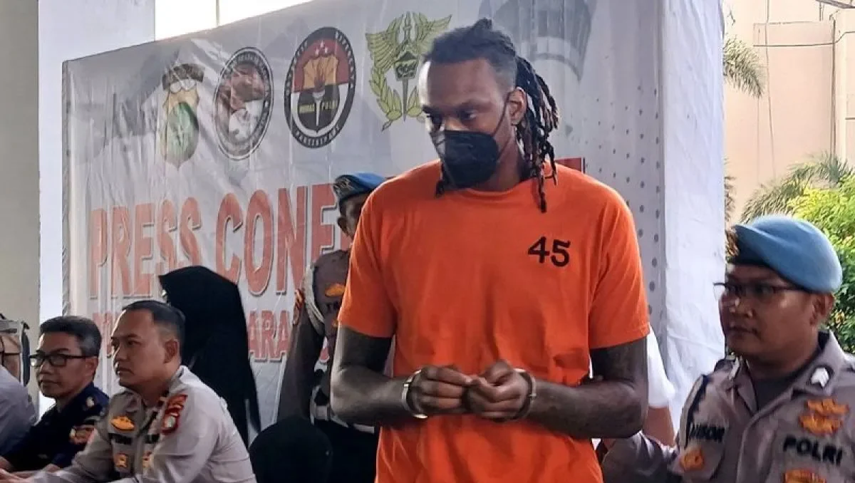 Pemain asing Tangerang Hawks Basketball, Jarred Dwayne Shaw (JDW) digiring petugas kepolisian Bandara Soetta usai ditampilkan ke hadapan publik dalam kasus narkoba, Tangerang Banten, Rabu (14/5/2025). (Anatara/Azmi Samsul Maarif)