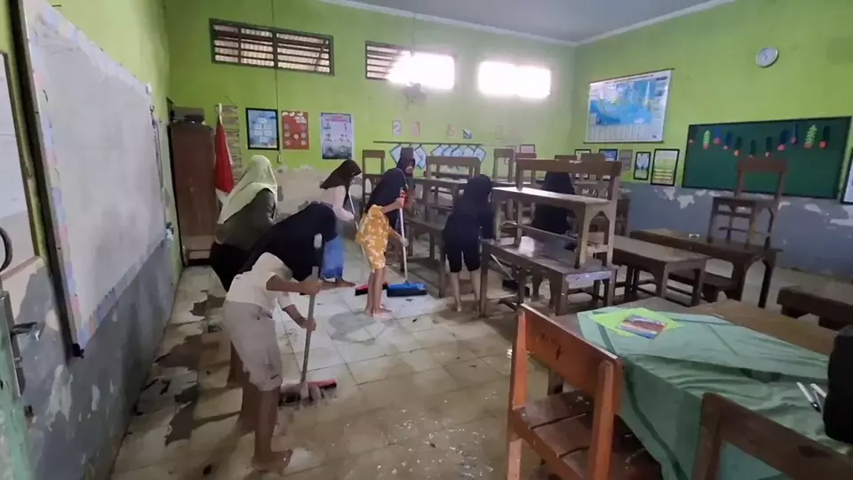 Para siswa-siswi hanya kerja bakti untuk membersihkan kelas dari siswa material lumpur yang terbawa banjir di Pati, Jawa Tengah. (Beritasatu/Jamaah)