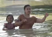 Seorang ibu dan anak menembus banjir di Desa Ploso, Kecamatan Karangtengah, Kabupaten Demak, Jawa Tengah, Minggu 18 Mei 2025. (Beritasatu/Jamaah)