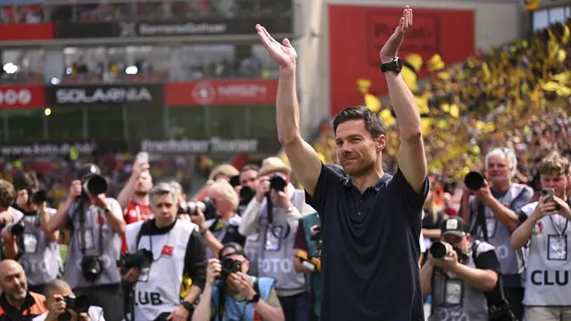 Xabi Alonso melambaikan tangan ke fans Bayer Leverkusen sebelum laga melawan Borussia Dortmund pada 11 Mei 2025 lalu. (Marius Becker/dpa via AP)