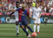 Penyreng Barcelona Lamine Yamal melepaskan tendangan di depan pemain Real Madrid Vinicius Junior dalam partai Luga Spanyol di Stadion Lluis Company, Minggu, 11 Mei 2025. - (AP/Joan Monfort)