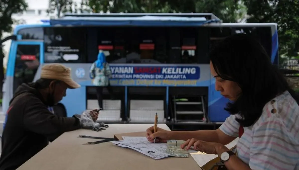 Image Credit Alif Bintang/Antara - Sejumlah warga mengisi berkas pembayaran pajak kendaraan bermotor di gerai pelayanan Samsat keliling di Lapangan Banteng, Jakarta, Kamis (5/12/2024). Pemprov DKI Jakarta memberikan program pemutihan Pajak Kendaraan Bermotor (PKB) dan insentiif Bea Balik Nama Kendaraan Bermotor (BBNKB) bagi wajib pajak yang membayar sebelum 31 Desember 2024.