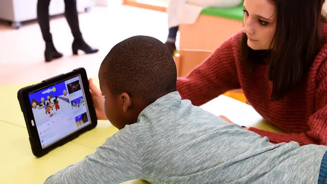 Image Credit Afp - Seorang perawat bersama salah satu anak sedang menonton dari layar tablet di Rumah Sakit Ecole di Neuilly-Plaisance, dekat Paris, 21 Maret 2017. Rumah sakit yang khusus untuk anak penderita autis ini baru saja dibuka untuk umum.