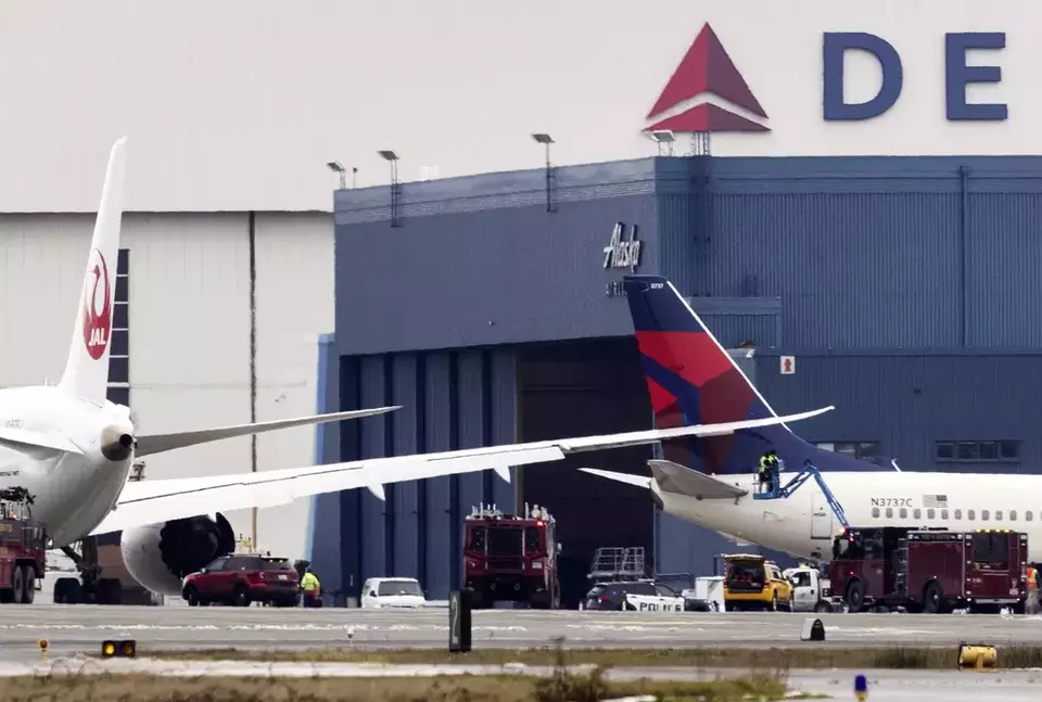 Image Credit AP - Pekerja memeriksa area di mana sayap pesawat Japan Airlines bertabrakan dengan ekor Delta Air Lines di ujung selatan landasan pacu di Bandara Internasional Seattle-Tacoma pada Rabu, 5 Februari 2025.