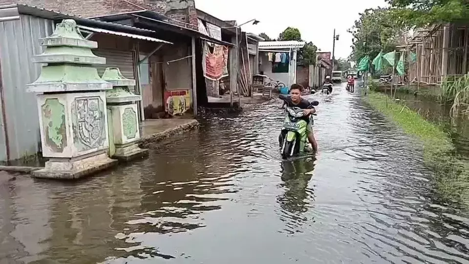 Image Credit Jmaah/Beritasatu - Warga Demak, Jawa Tengah, membawa motornya melintas genangan banjir, Sabtu 1 Februari 2025.