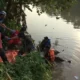 Petugas mengangkat mayat pria tanpa kelamin yang ditemukan di Sungai Rejoto, Mojokerto. (Beritasatu/Achmad Supriyadi)