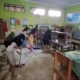 Para siswa-siswi hanya kerja bakti untuk membersihkan kelas dari siswa material lumpur yang terbawa banjir di Pati, Jawa Tengah. (Beritasatu/Jamaah)