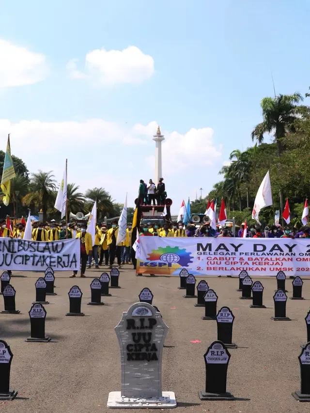 Puluhan nisan berjejer rapi di sekitar area Monas, Jakarta, pada Hari Buruh Internasional, Sabtu (1/5/2021). Nisan hitam itu dihiasi tulisan yang mewakili perasaan para buruh, Antara lain RIP PHK Murah, Bebasnya Outsourcing, RIP Cuti Hamil, RIP Satuan Upah-Perjam. (Liputan6/Angga Yuniar)