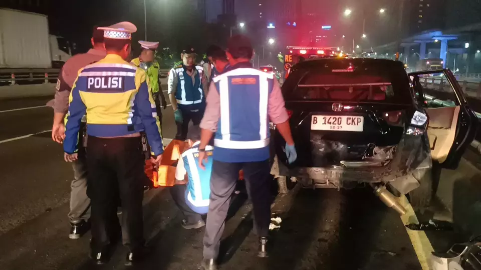 Petugas mengevakuasi korban dari mobil Honda Mobilio yang terguling di Tol Dalam Kota, Jakarta Selatan, Jumat (2/5/2025) dini hari. (Beritasatu/Yohannes Tohap Tobing)
