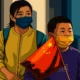Ilustrasi - Seorang anak laki-laki yang mengenakan masker membawa bendera Tiongkok saat dia berjalan di sepanjang jalan perbelanjaan pejalan kaki di Beijing pada 6 Oktober 2022.