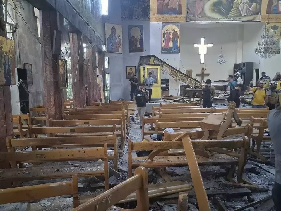 Wartawan dan pekerja pertahanan sipil memeriksa kerusakan di dalam gereja Mar Elias tempat seorang pengebom bunuh diri meledakkan dirinya di Dweil'a di pinggiran Damaskus, Suriah, Minggu 22 Juni 2025. (AP)