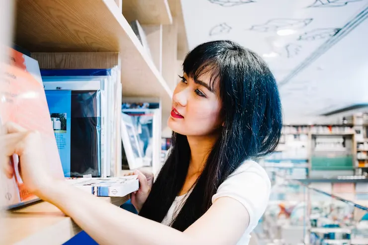 asian woman browsing bookshelves 23 2147689823