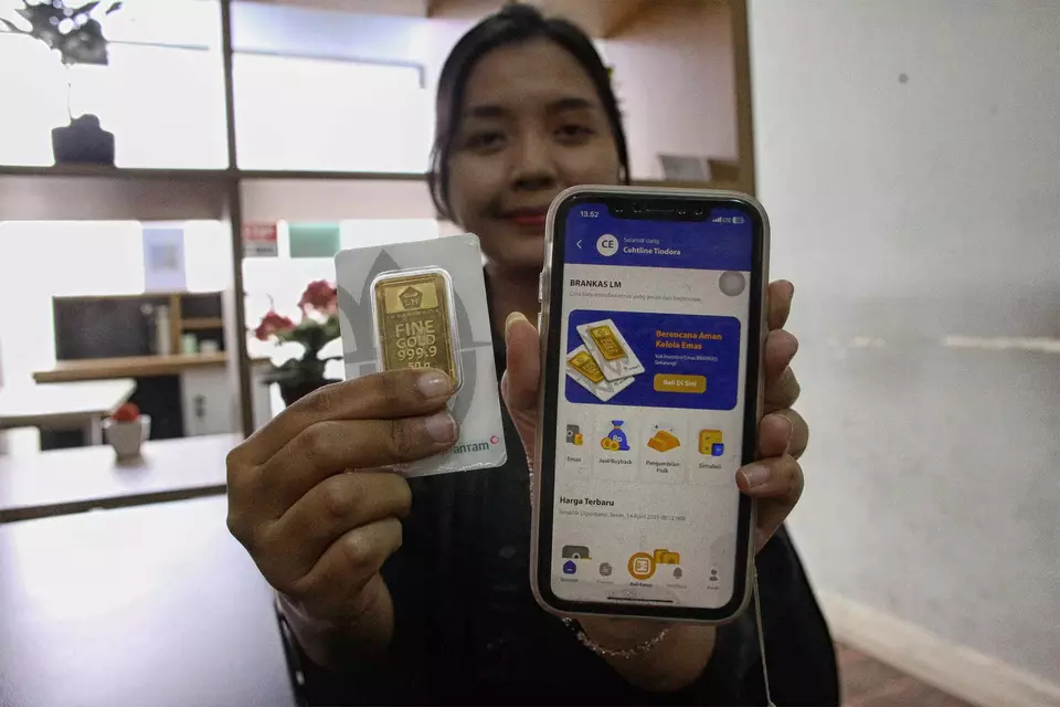 Petugas menunjukan aplikasi memesan emas Antam dan emas batangan Antam 50 gram di Butik Emas Logam Mulia Antam Jalan T.B Simatupang, Jakarta Selatan, (Beritasatu/Joanito De Saojoao)