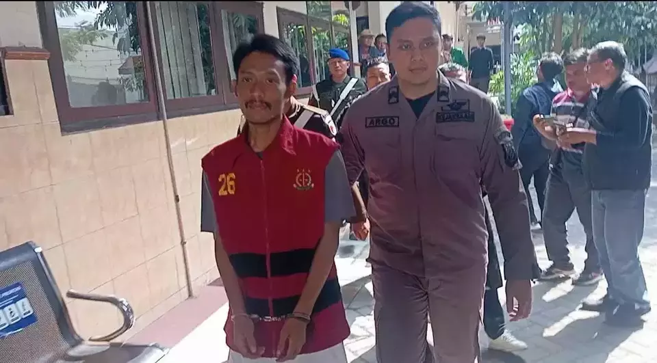 Yusak Cahyo Utomo (pakai rompi tahanan), terdakwa pembunuh satu keluarga digiring petugas di PN Kediri, Kamis (3/7/2025). (Beritasatu/Muajijin)
