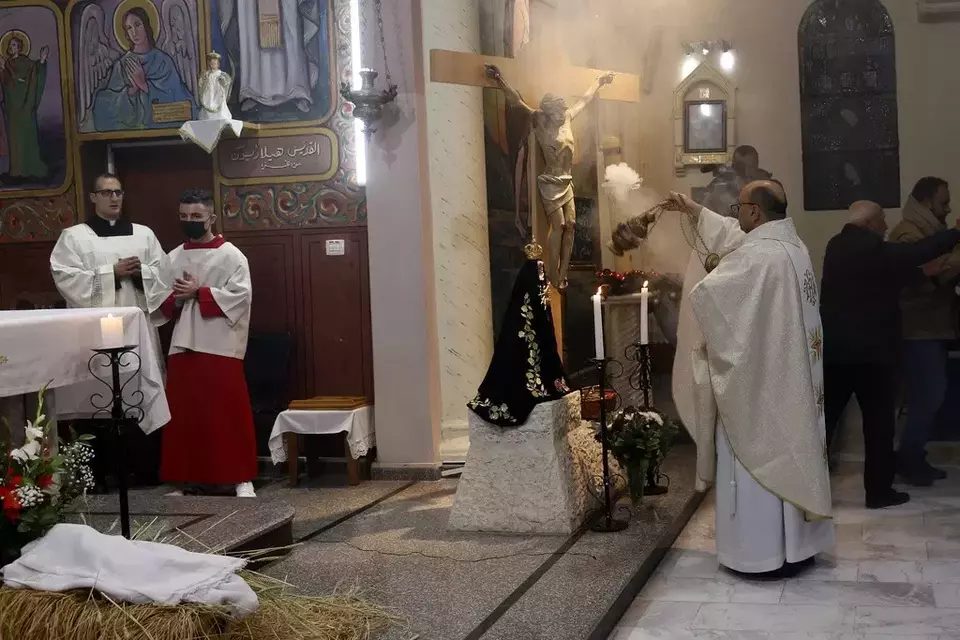 Pastor Gabriel Romanelli, pastor paroki Latin Jalur Gaza,berdoa dalam misa Malam Natal tengah malam di Gereja Katolik Keluarga Kudus Deir Al Latin di Kota Gaza. (AP)