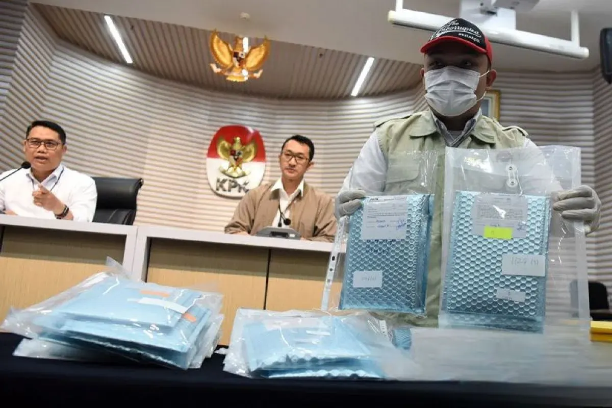 Plt Deputi Penindakan dan Eksekusi KPK Asep Guntur Rahayu (kiri) bersama Juru Bicara KPK Budi Prasetyo (tengah) menyaksikan petugas KPK menunjukkan barang bukti kasus dugaan korupsi pengadaan mesin electronic data capture (EDC) Bank Rakyat Indonesia (BRI) tahun 2020-2024 saat rilis pengungkapan perkara di Gedung Merah Putih KPK, Jakarta, Rabu (9/7/2025).
