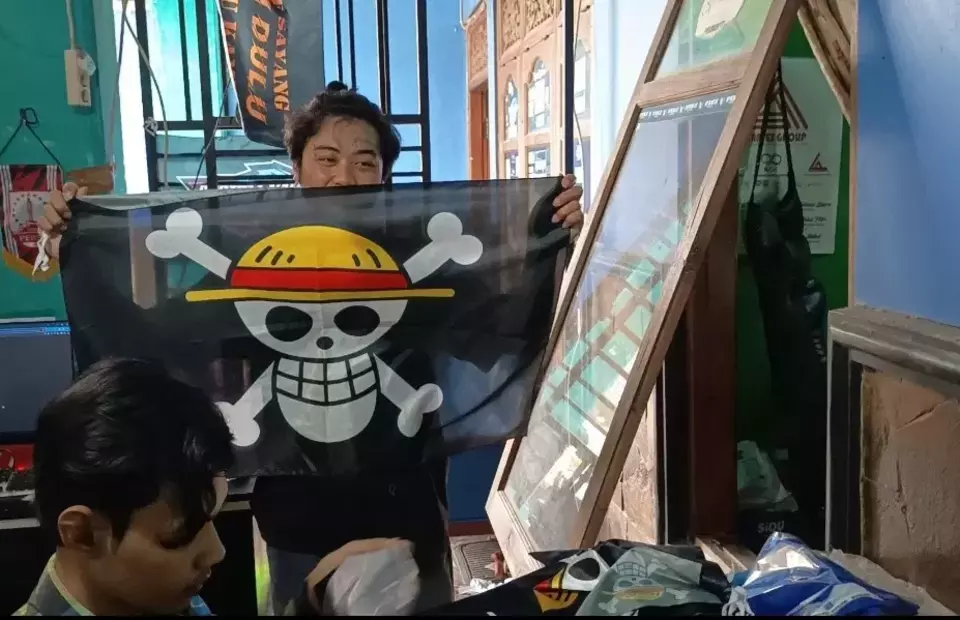 Penjahit di Desa Jati Kecamatan Jaten, Karanganyar, Jawa Tengah menunjukkan bendera One Piece yang sedang dibuatnya, (Beritasatu/Abdul Alim Muhammad Zamzami)