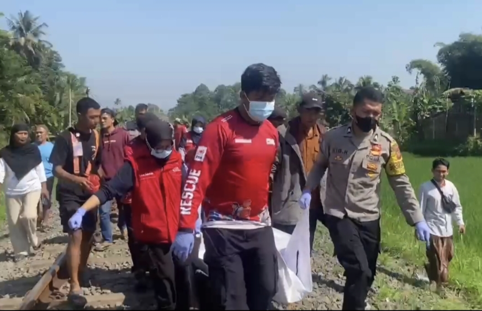 Petugas mengevakuasi jenazah Ade Rahmat (62) yang tewas tertabrak kereta api di perlintasan tanpa palang pintu jalur rel Paledang, Jalan Cicantayan, Desa Cimahi, Kecamatan Cicantayan, Kabupaten Sukabumi, Jawa Barat, Sabtu (2/8/2025). (Beritasatu/Riza)
